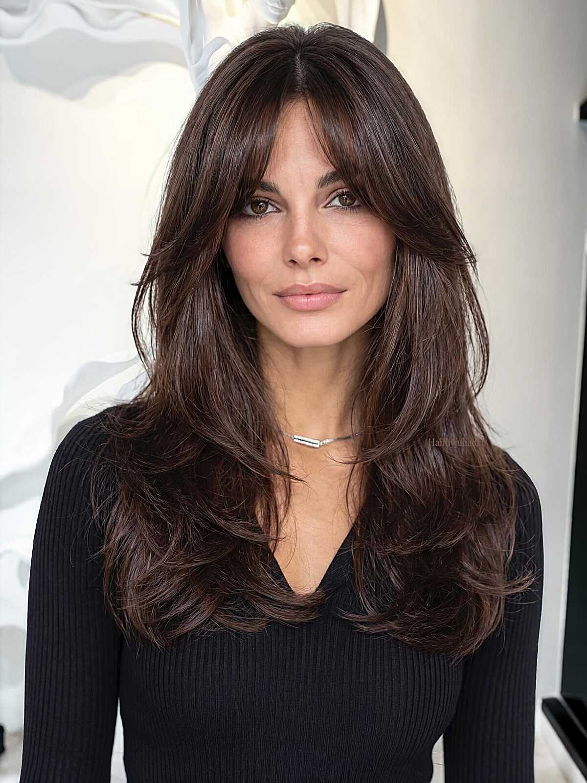 Dark chocolate layered hair with full textured curtain bangs