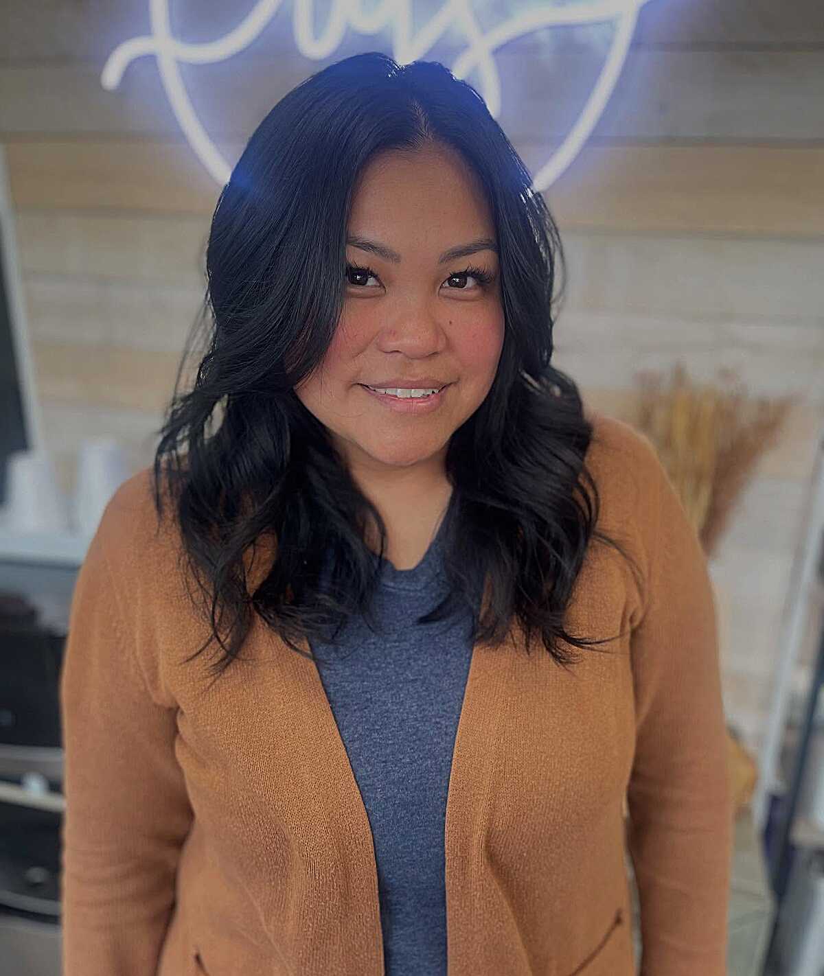 Bouncy black wavy mid length cut with lots of volume