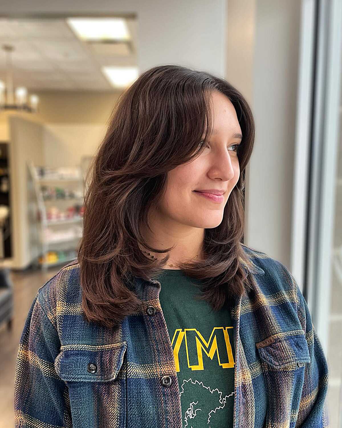 Brunette mid length layers with curtain framing and bounce
