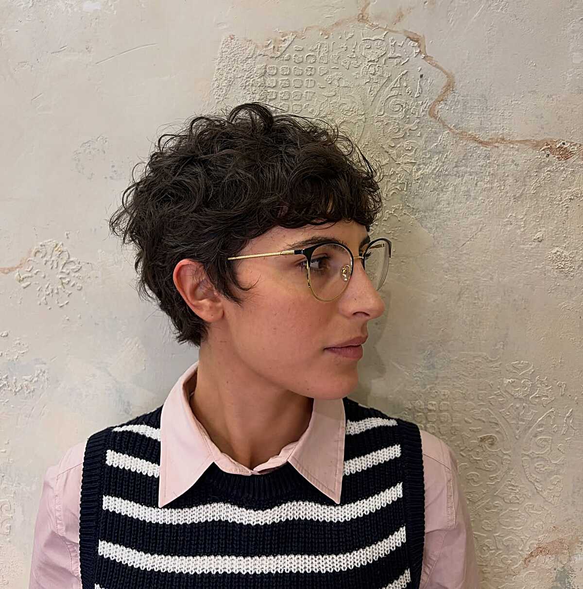 Short curly brunette pixie with volume on top