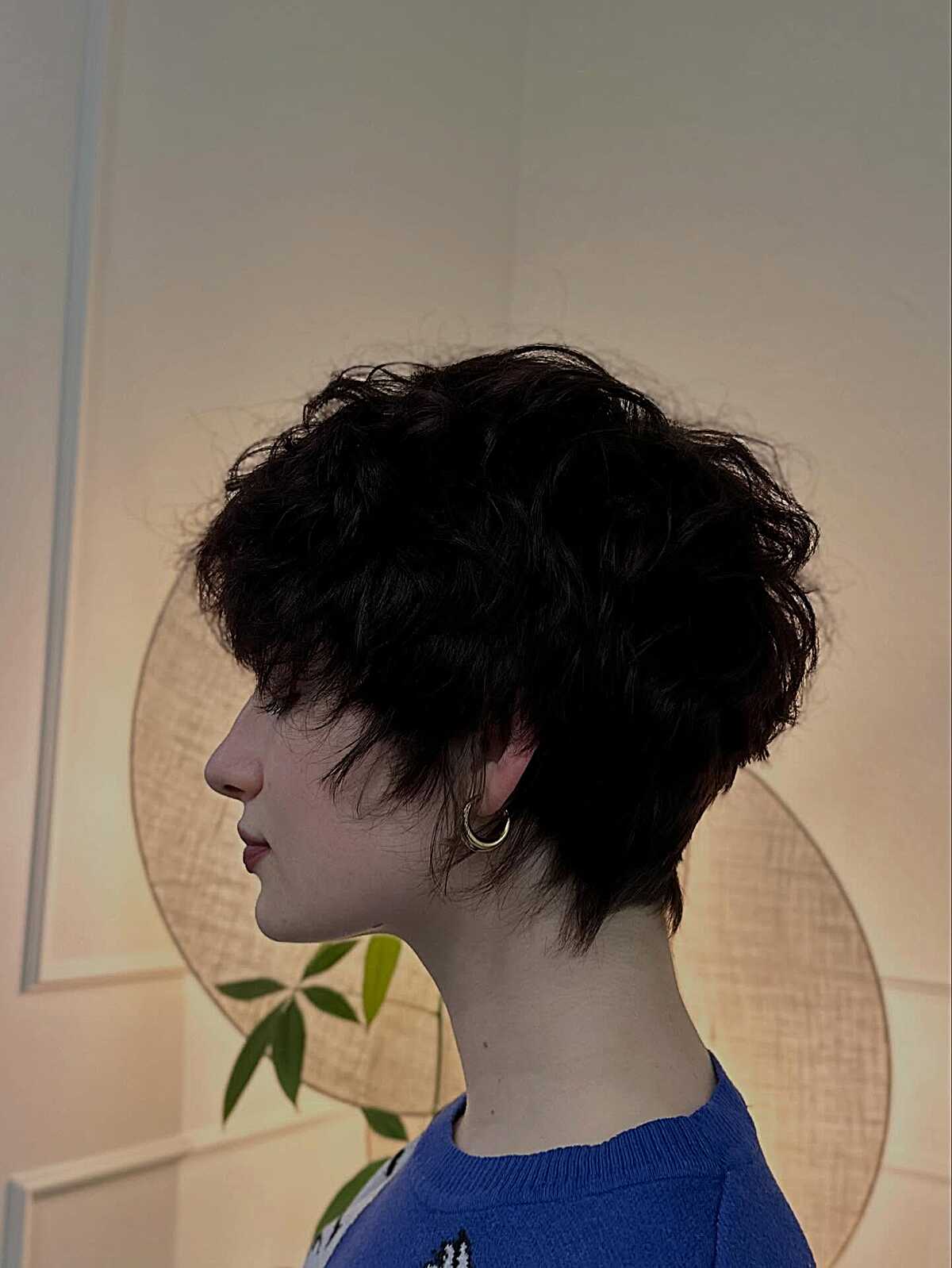 Black curly pixie with volume at the crown and nape
