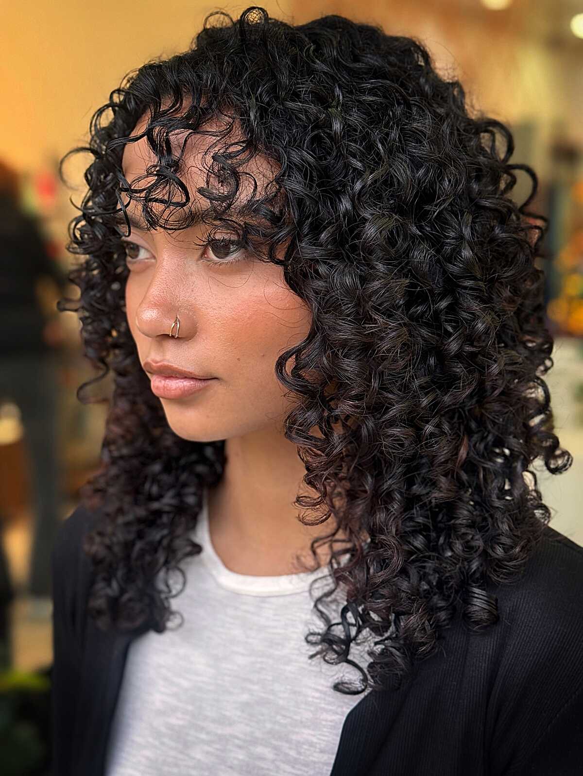 Black curly mid length shag with defined curly bangs
