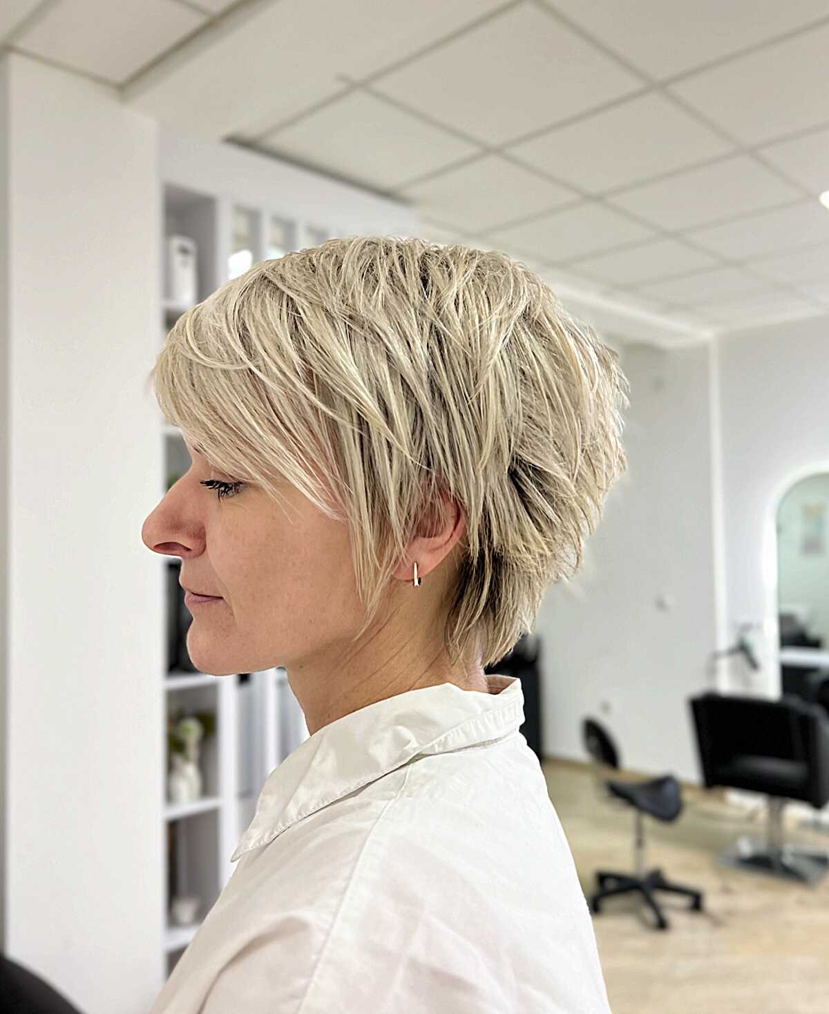 Layered ash blonde pixie with feathered nape texture