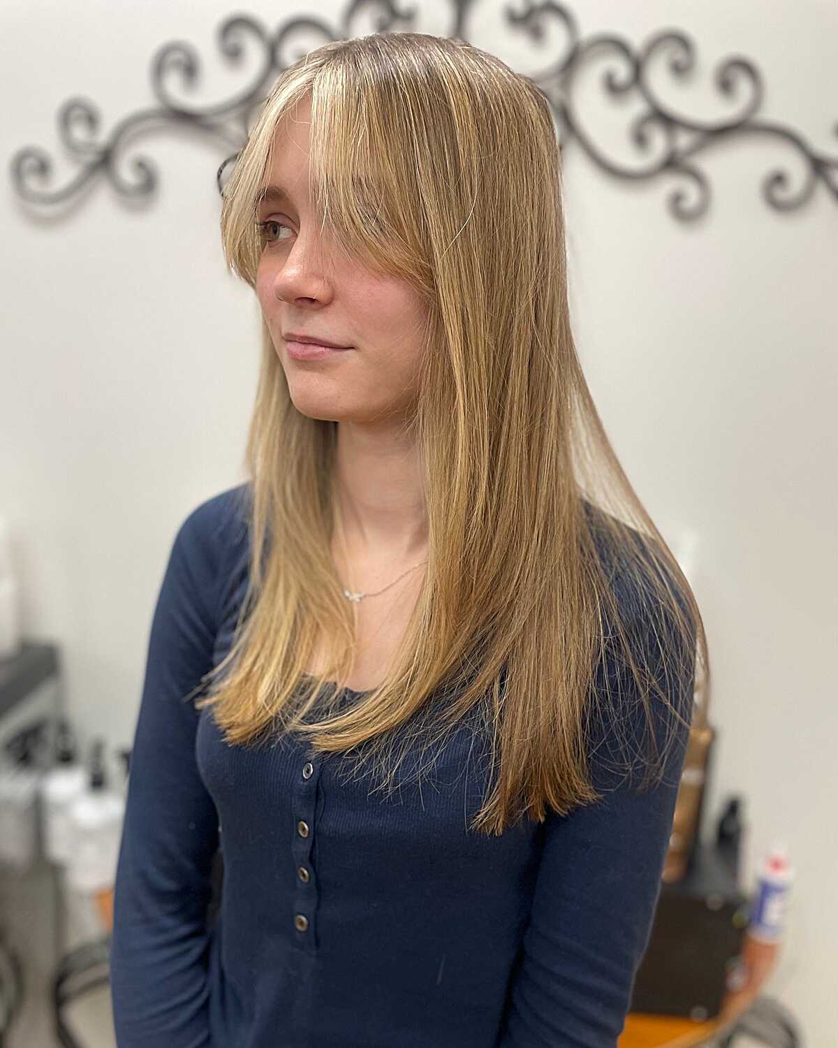 Long straight honey blonde hair with feathered curtain bangs