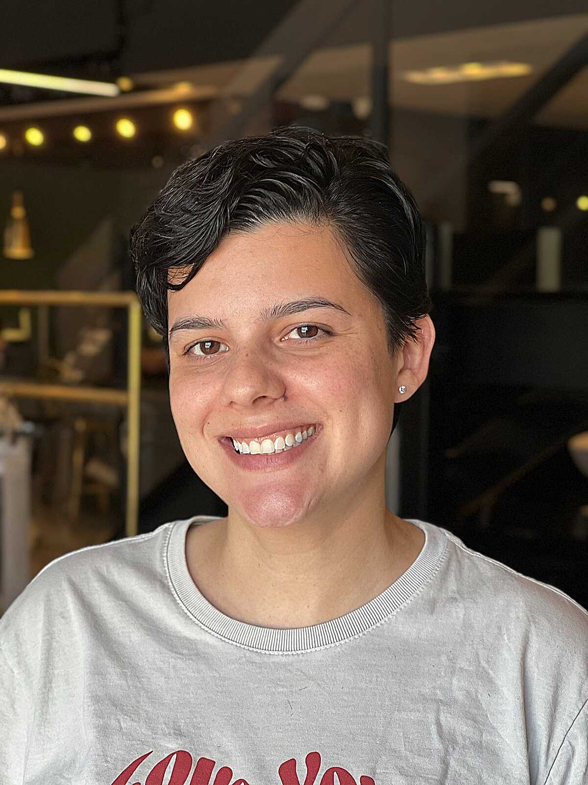 Short dark wavy pixie swept softly to one side