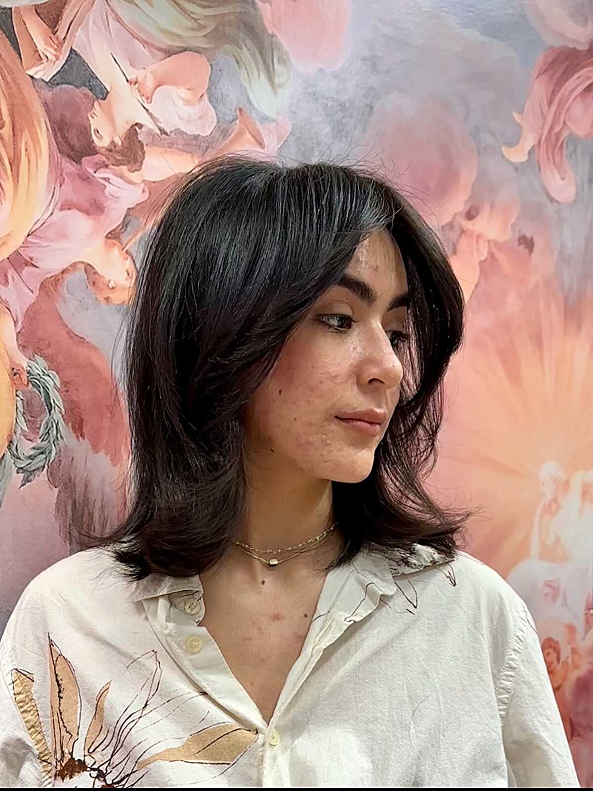 Dark mid length cut with side-swept face-framing layers