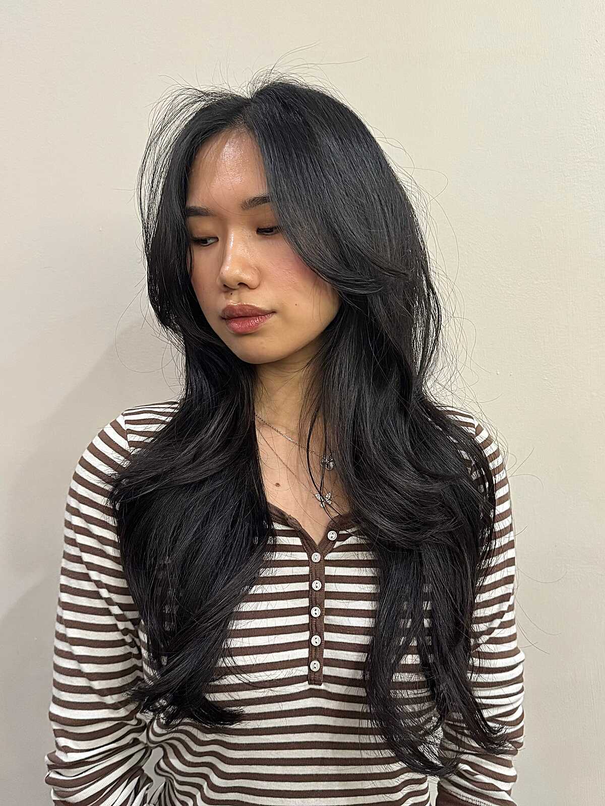 Long sleek black hair with curtain bangs and flicked ends