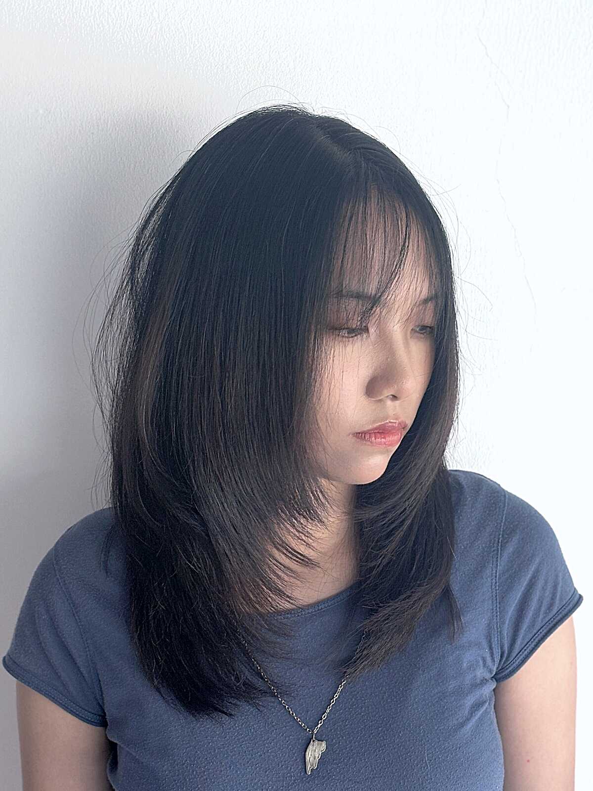 Sleek black straight mid length with long curtain bangs