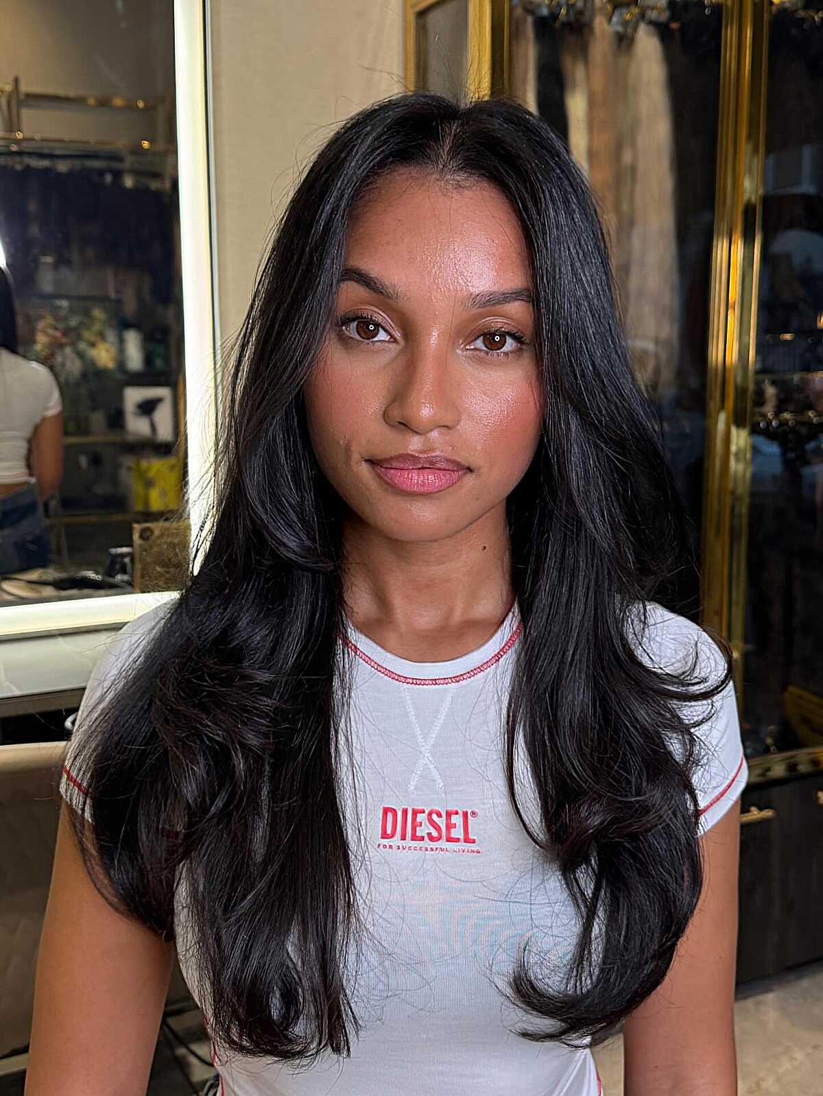 Voluminous long black blowout hairstyle with parted bangs