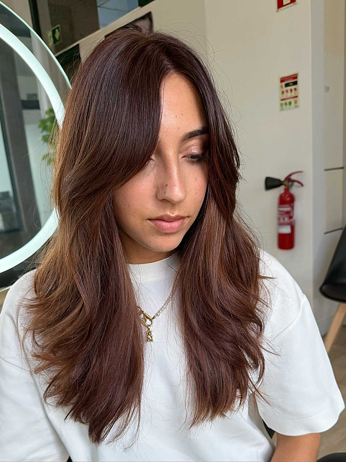 Long warm chestnut brown wavy hair with curtain bangs