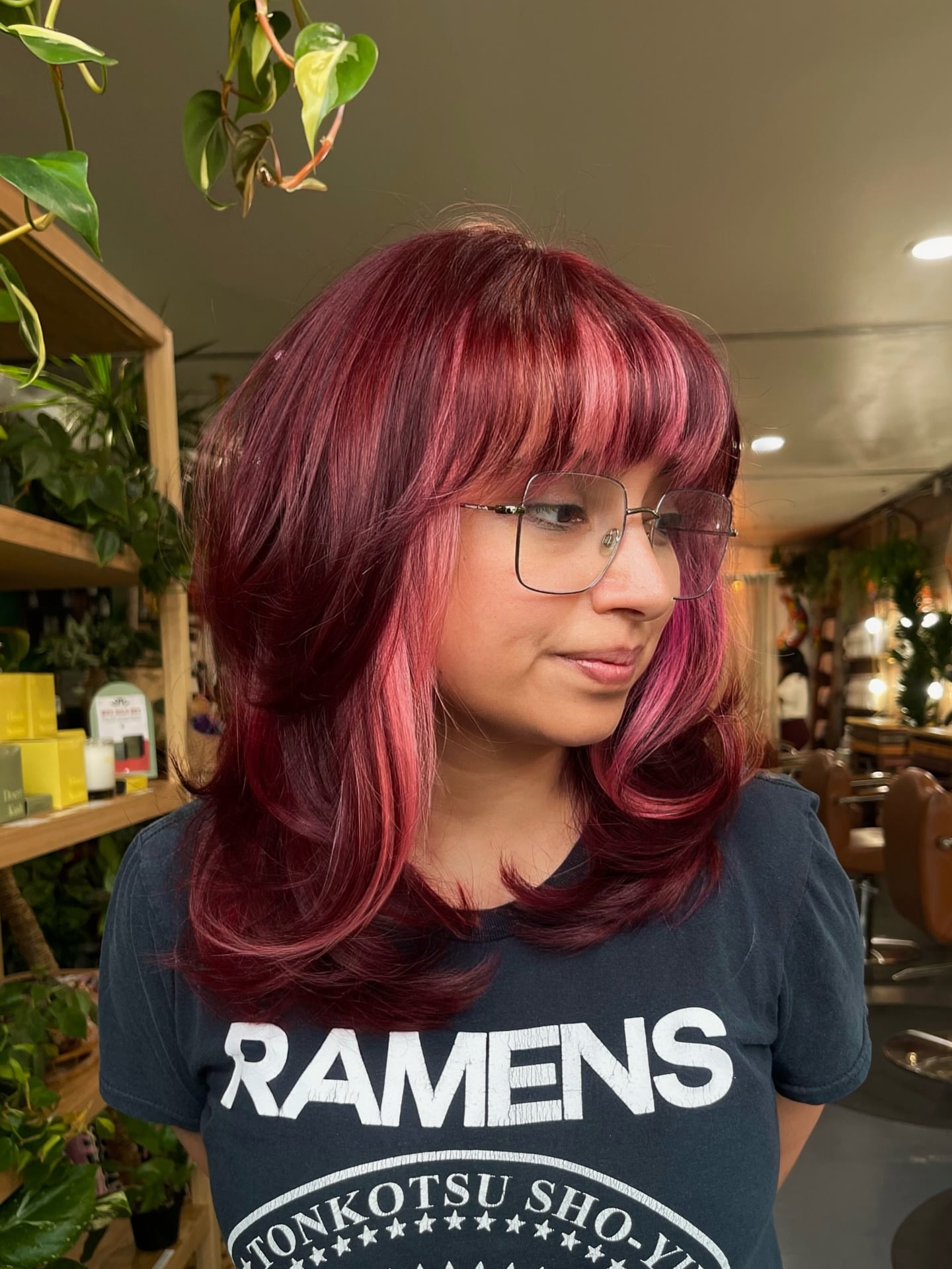 Cranberry red medium layered hair with straight bangs