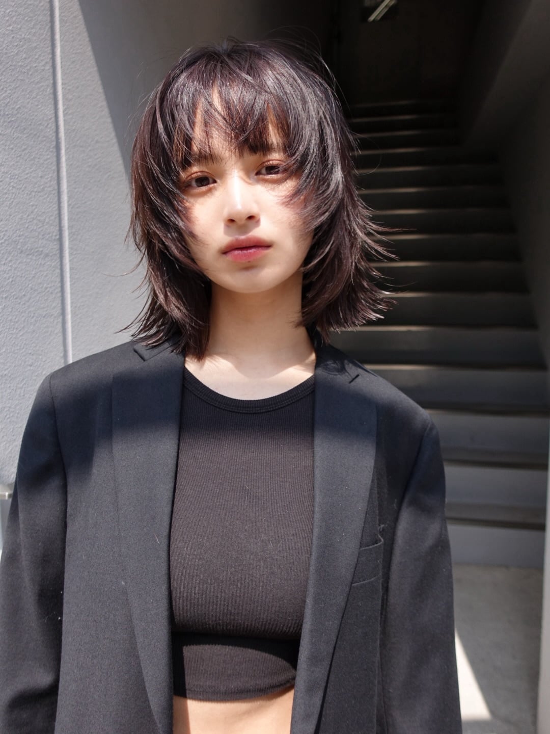Dark brunette razored wolf cut with choppy fringe