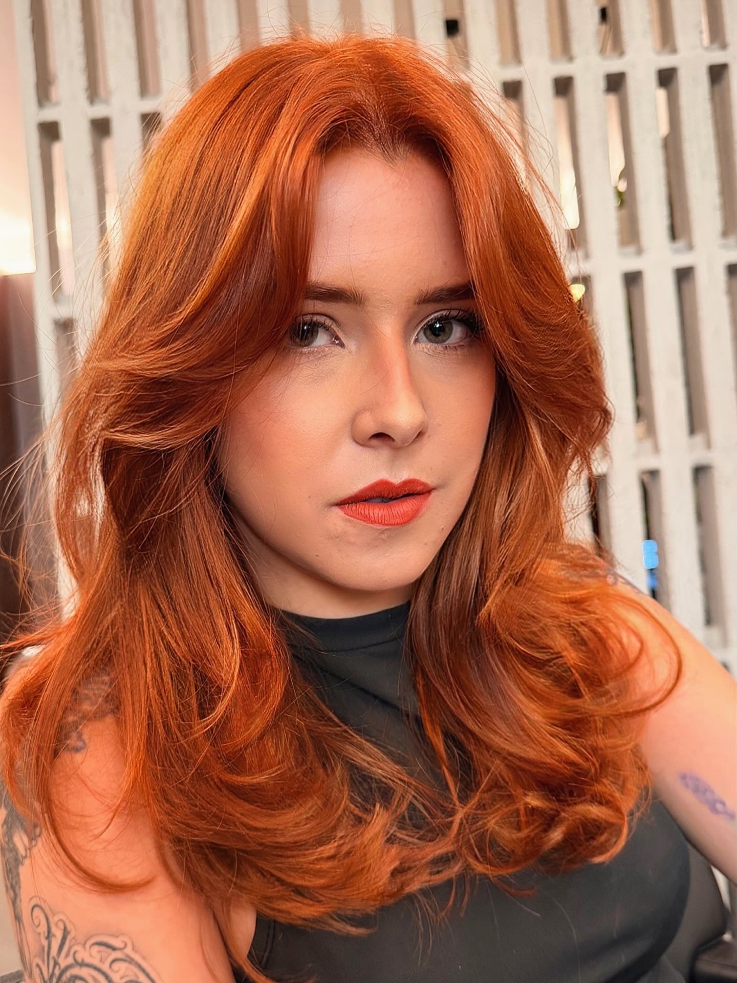 Vibrant copper red hair with curtain layers and waves