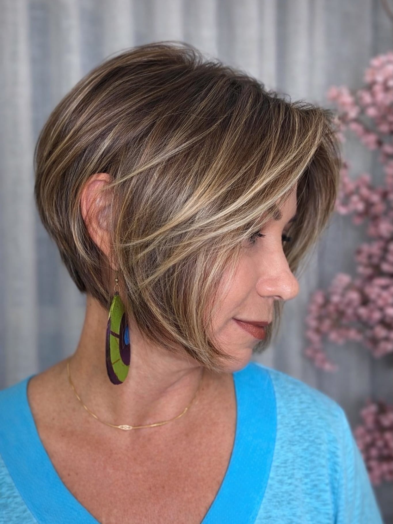 Short stacked bob with blonde highlights and side-swept fringe