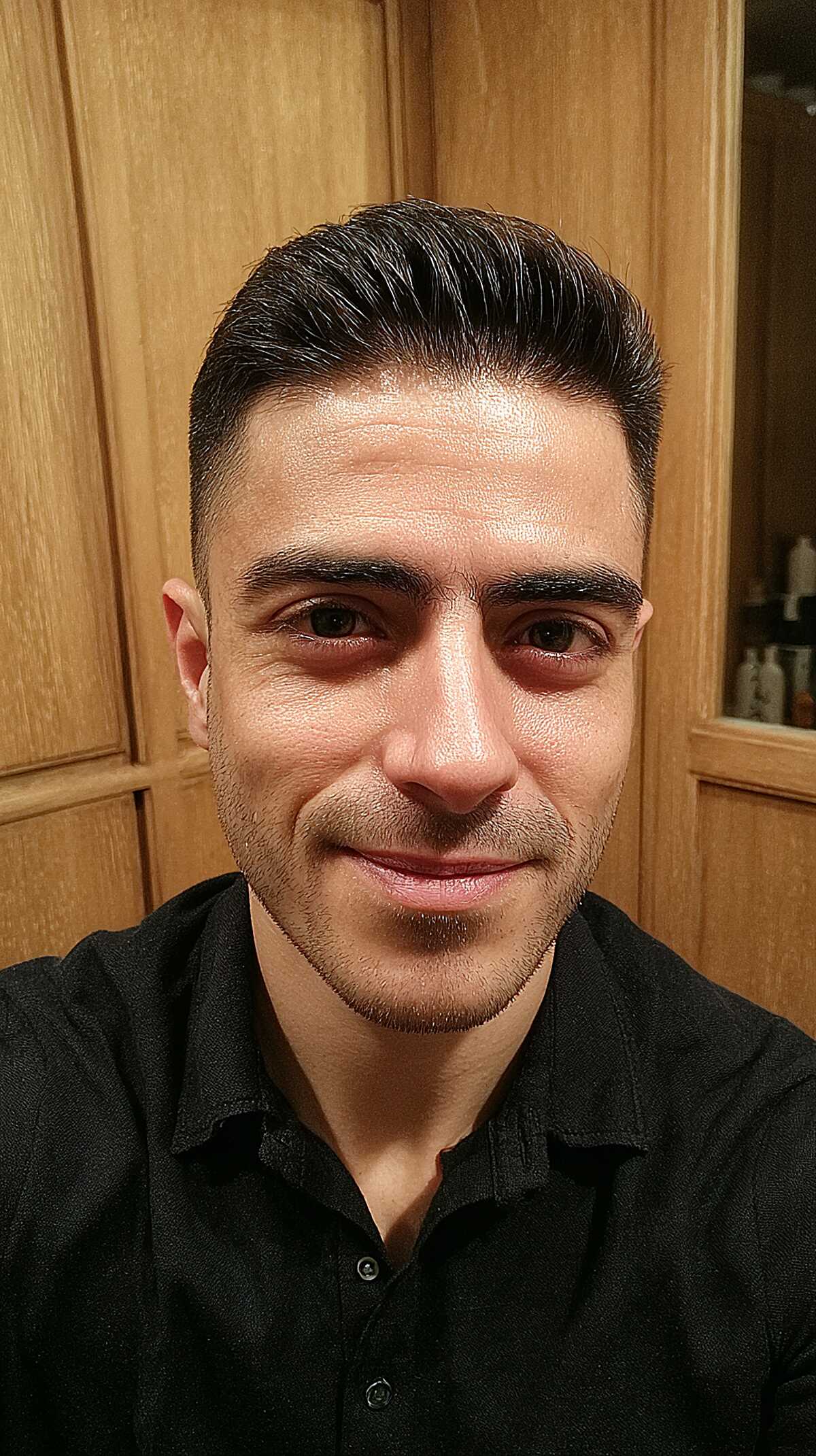 Polished side-swept men's haircut with a clean taper