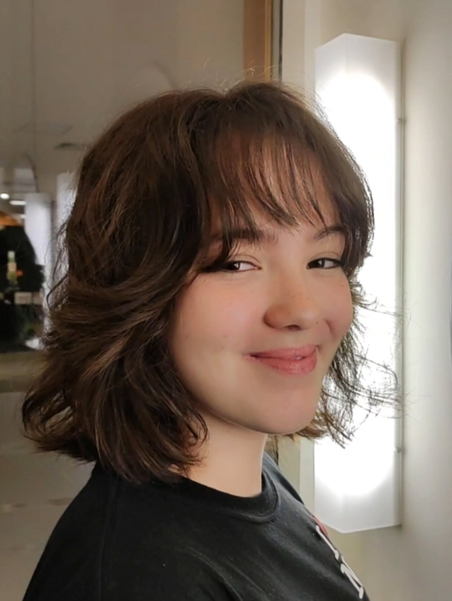 Chin-length wavy brunette shag bob with wispy bangs