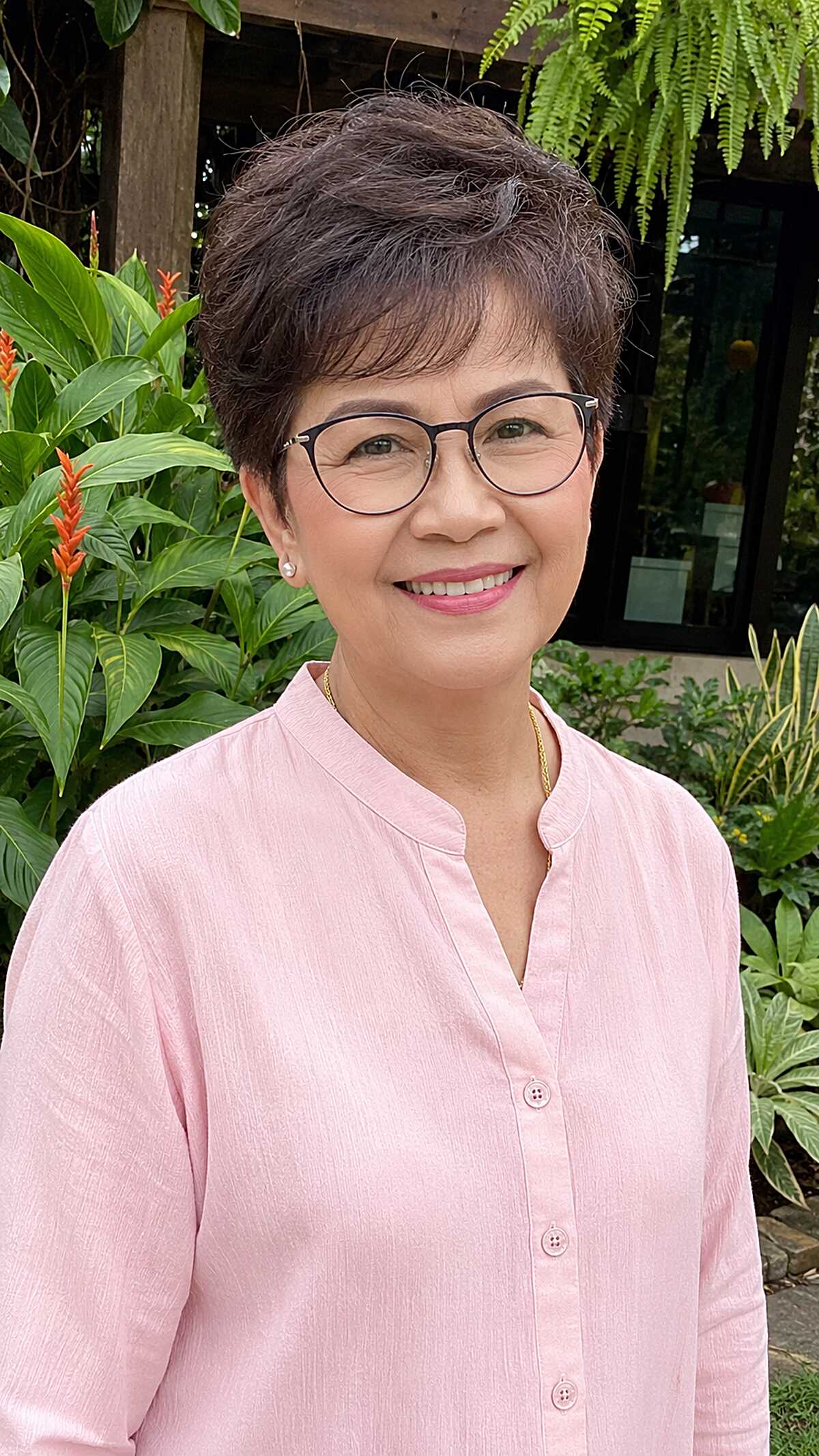 Wavy dark brown pixie cut with black rectangular glasses