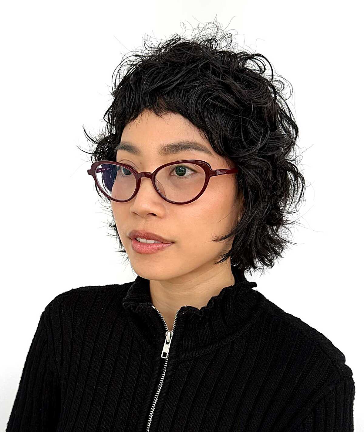 Black curly pixie cut with wispy bangs and glasses