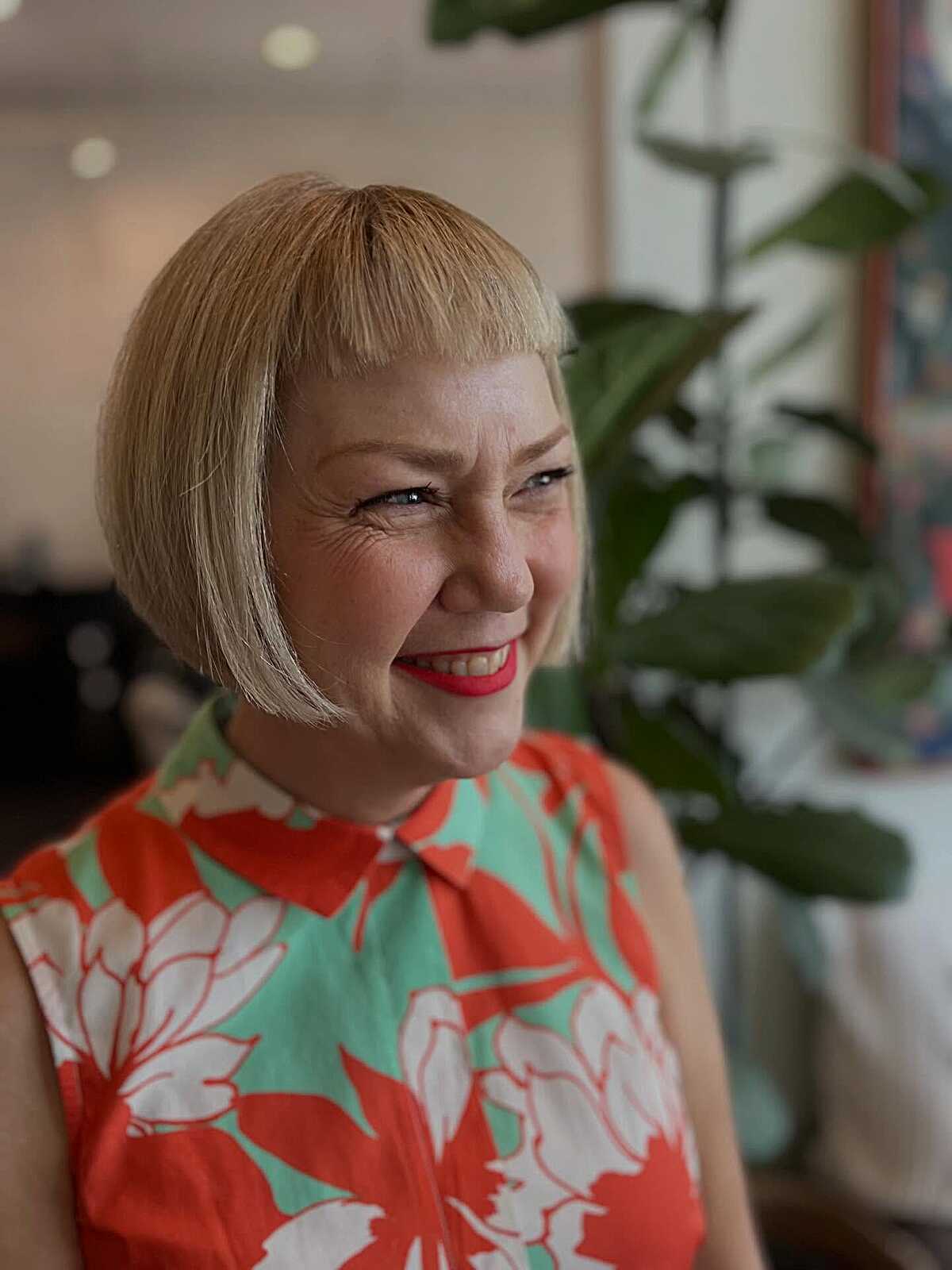 Warm blonde chin bob with micro fringe and red lipstick