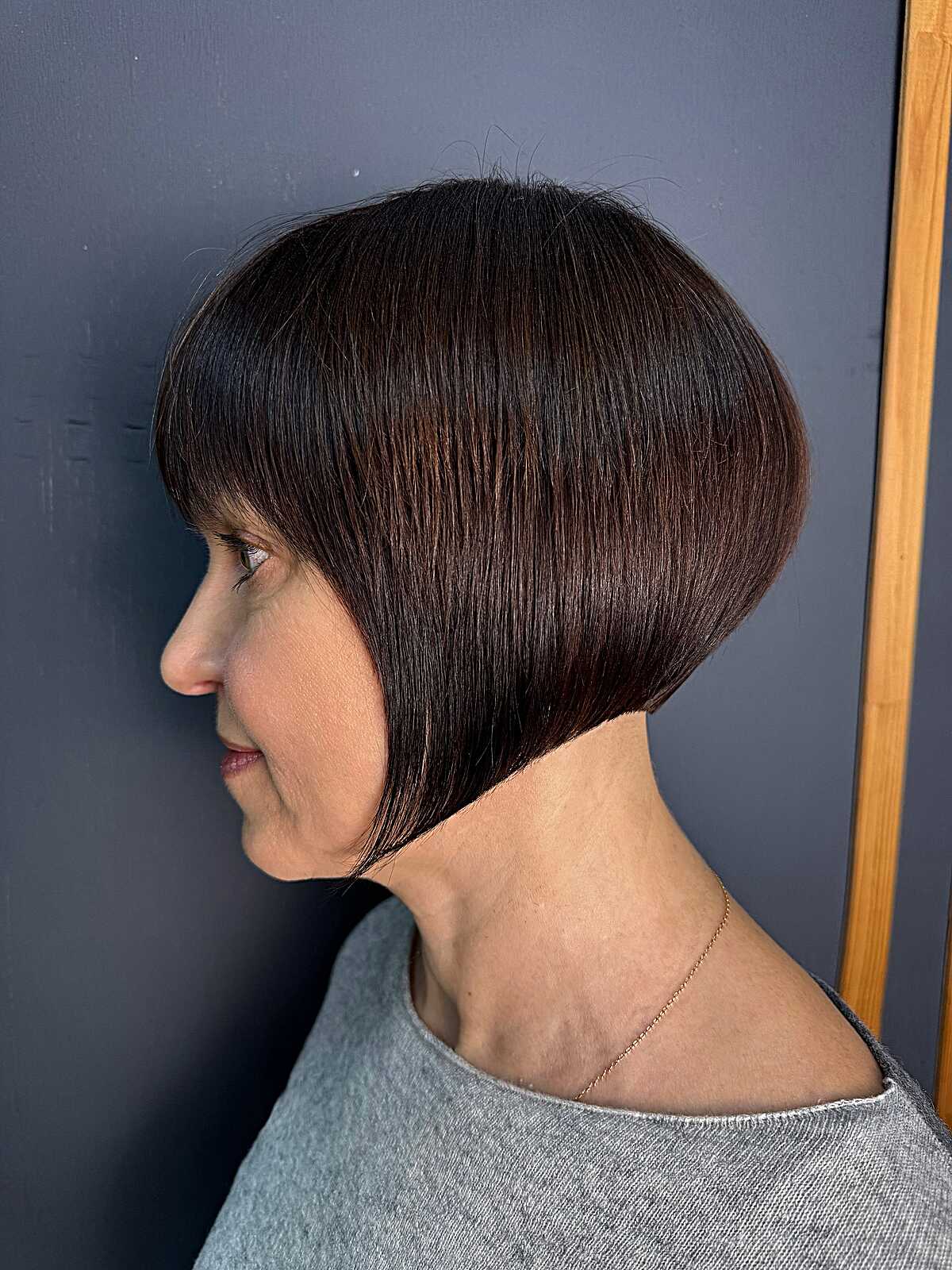 Deep mahogany graduated bob with bangs side profile