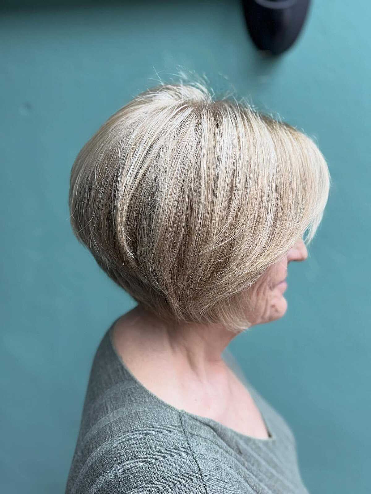 Polished stacked ash blonde chin-length bob side view