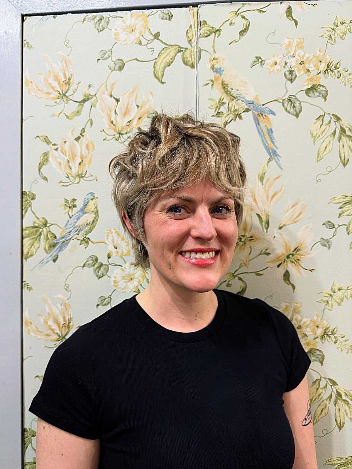 Sandy blonde curly pixie crop with tousled top