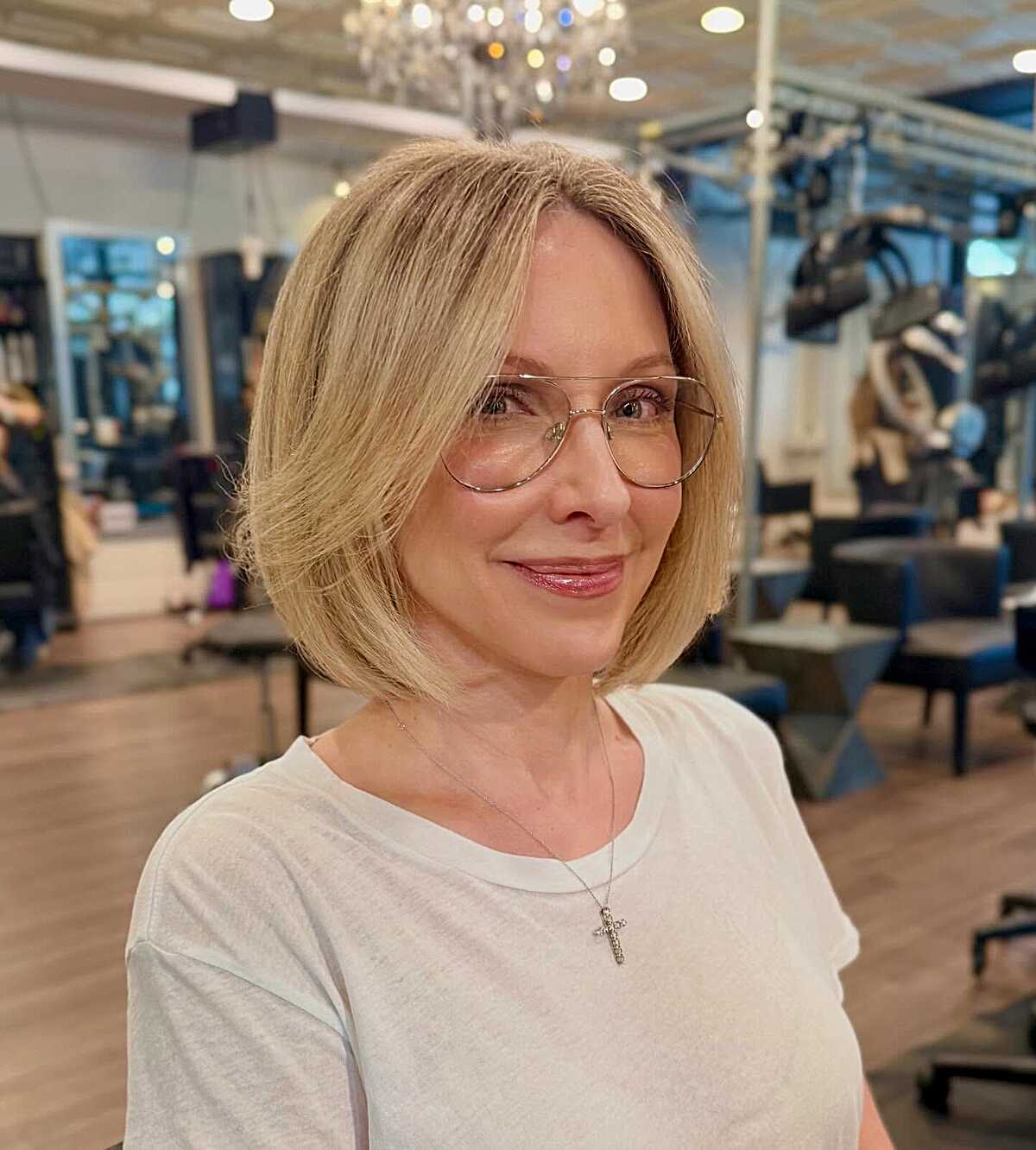 Soft blonde chin-length bob with side sweep and glasses