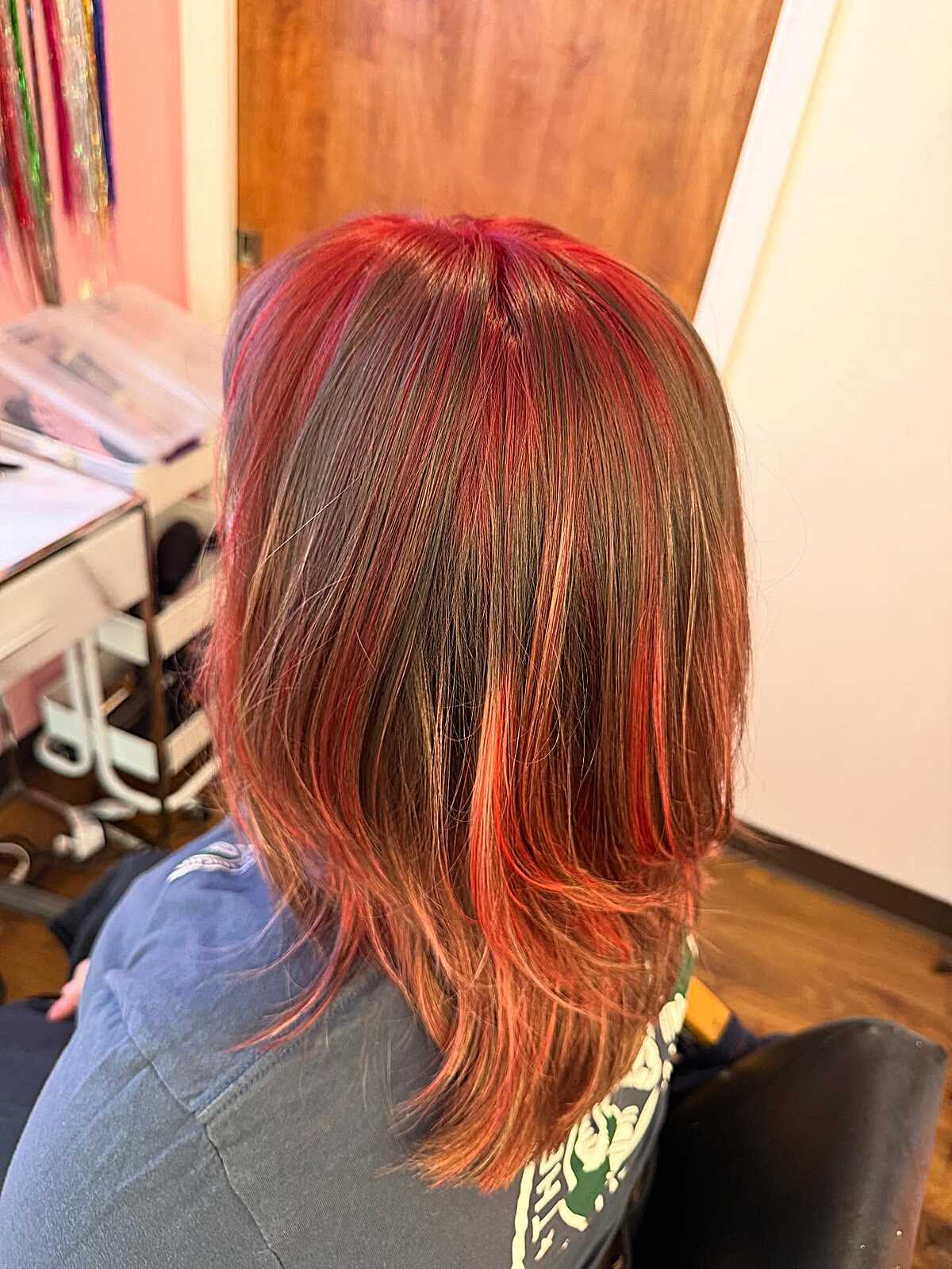 Short brown bob with bright coral red chunky highlights