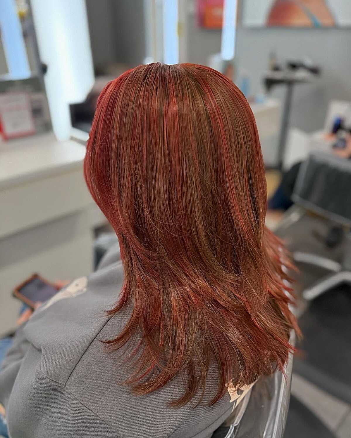 Medium layered hair in warm burnt sienna red-brown tones