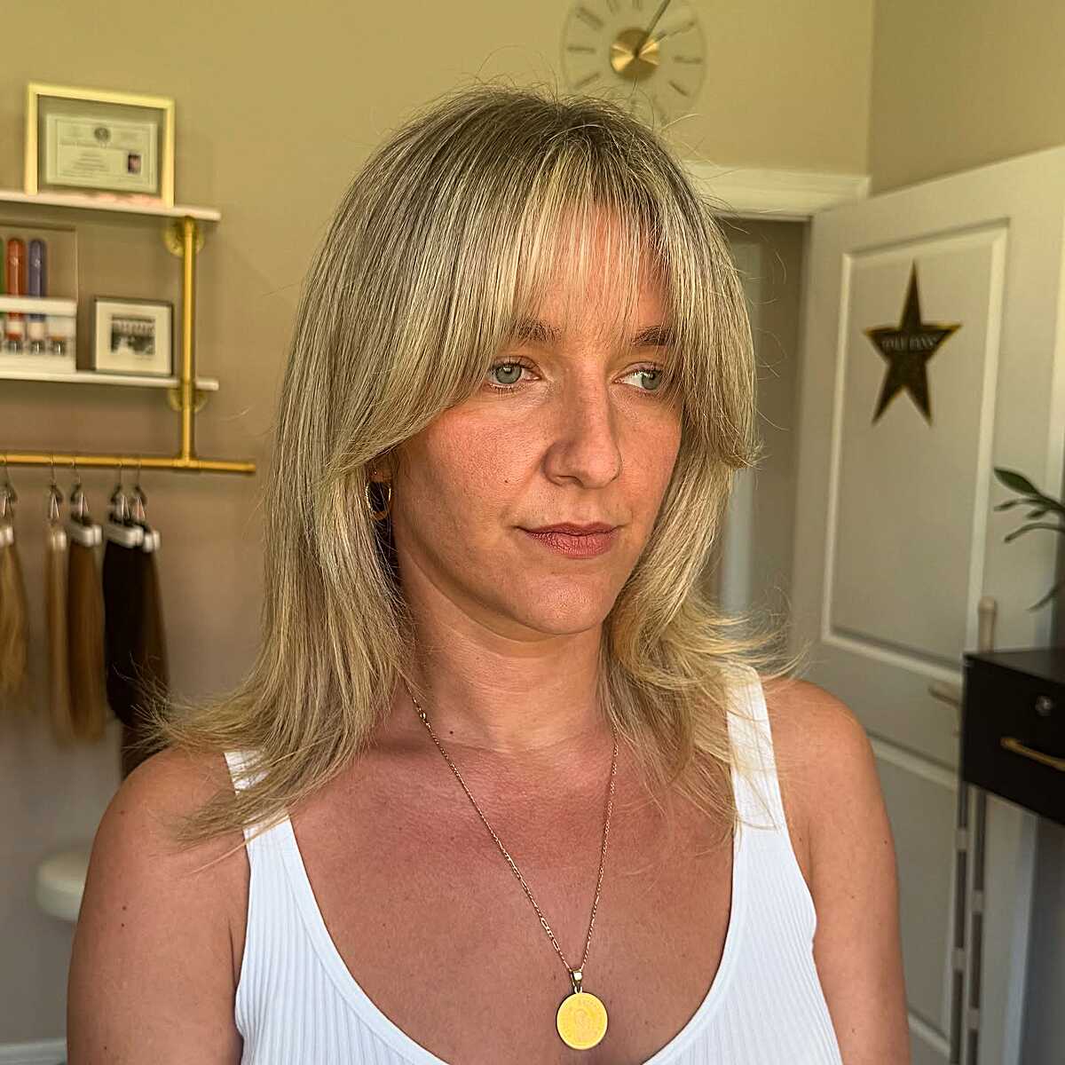 Buttery blonde medium layers with wispy shag-style bangs