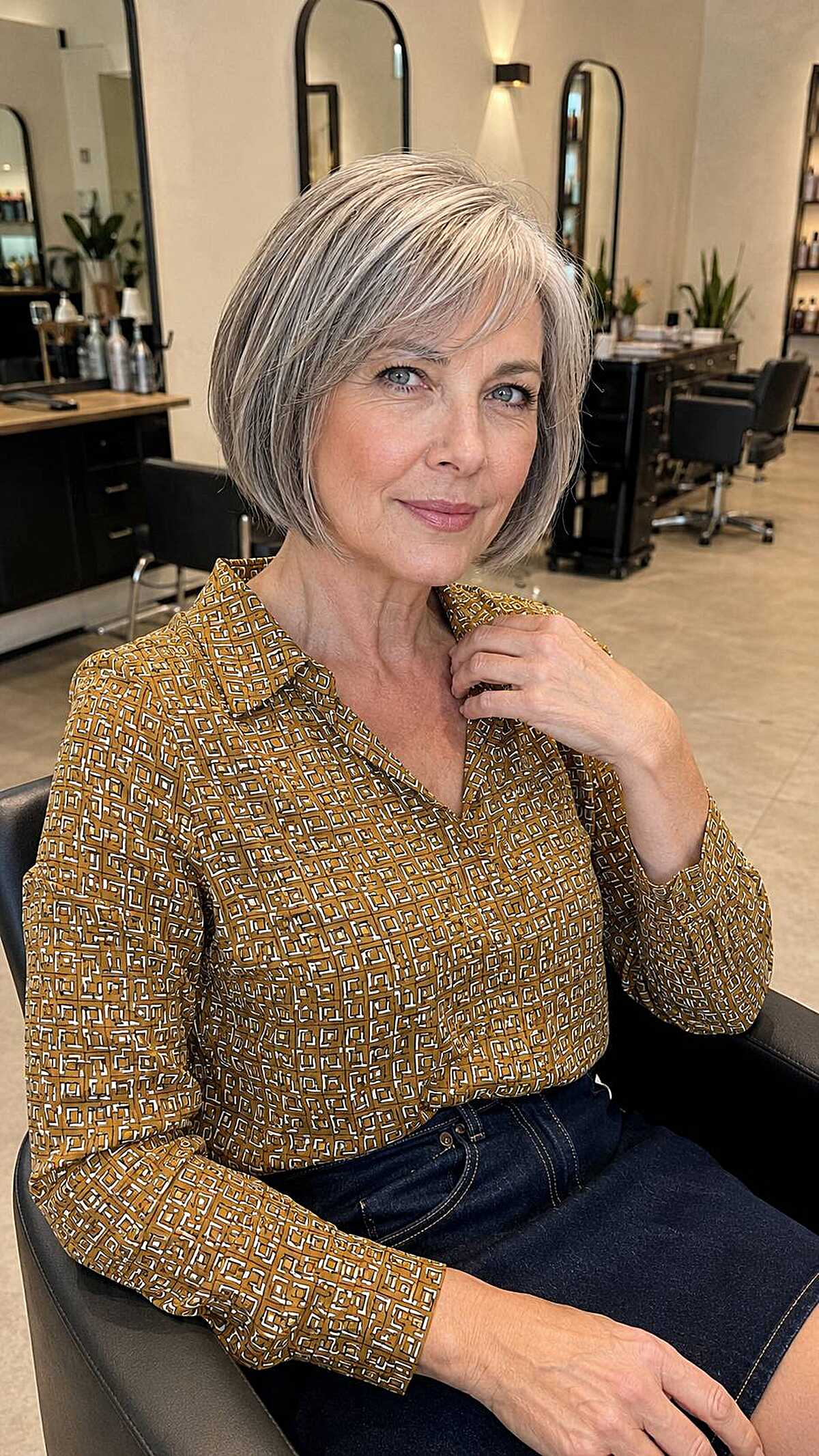 Chin-length silver blonde bob with rounded shape and bangs