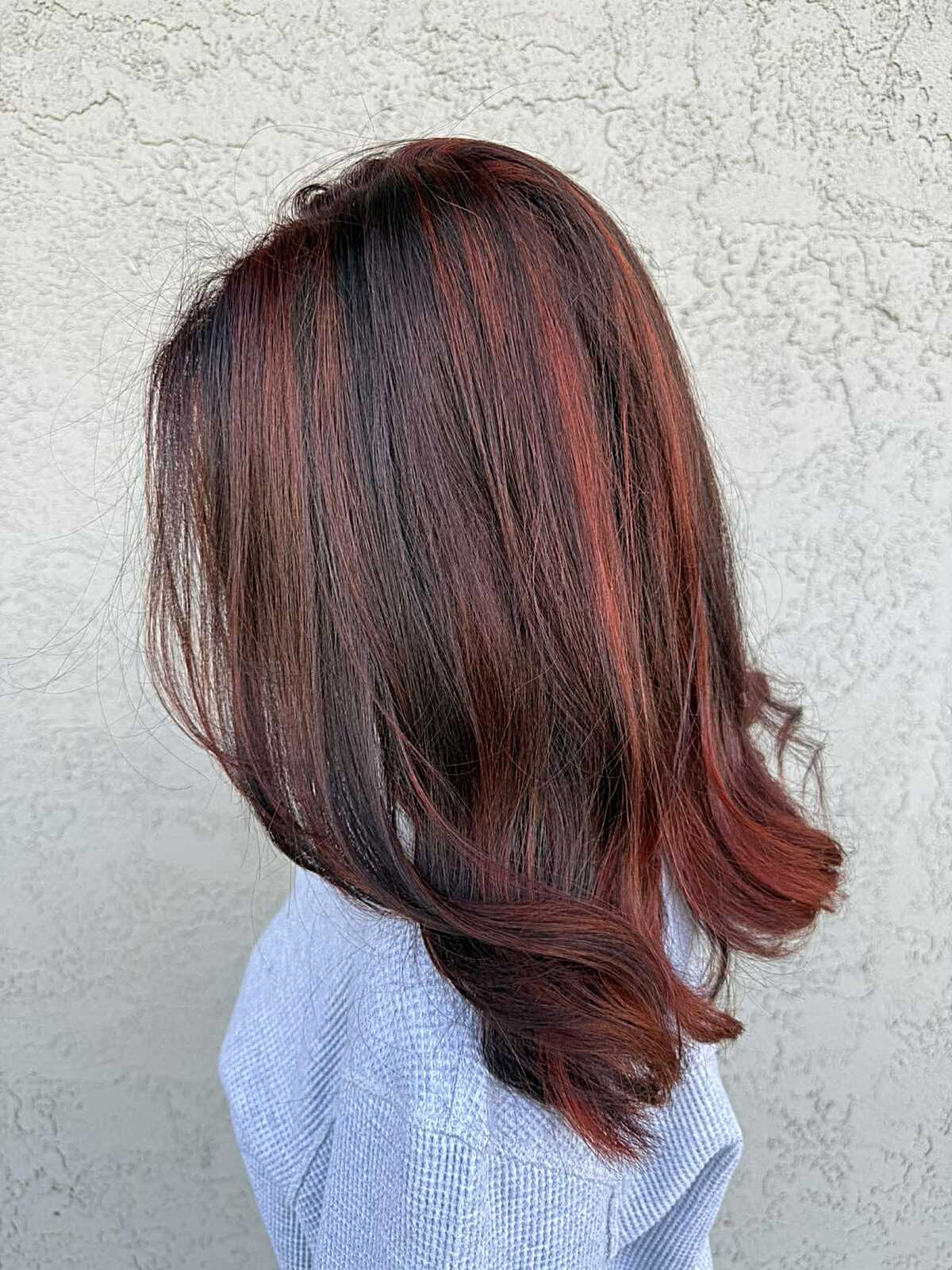 Dark cherry red highlights woven through chocolate brown lob