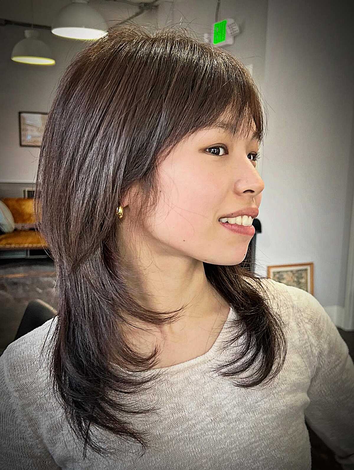 Medium layered cut with full fringe and wispy long ends