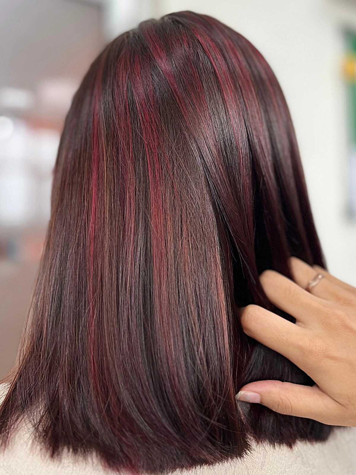 Glossy dark brown lob with precise true red highlight slices