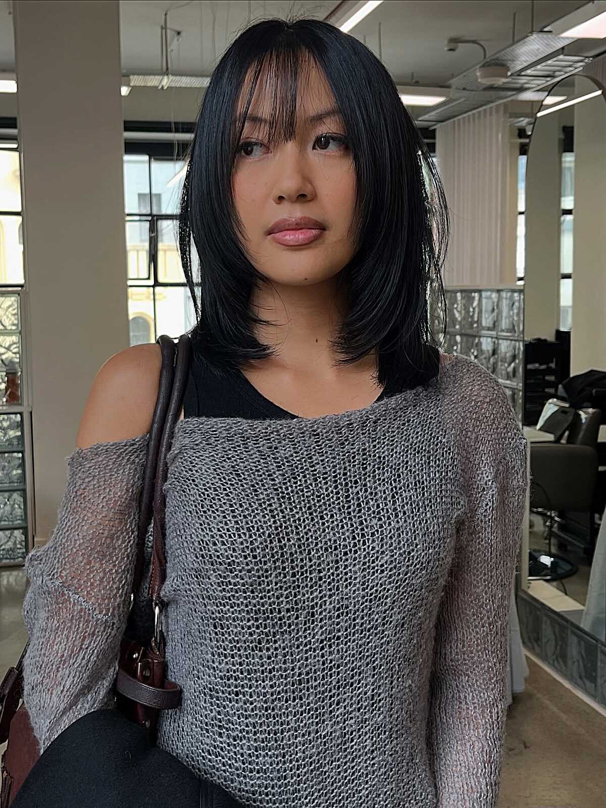 Black medium layered cut with wispy bangs on straight hair