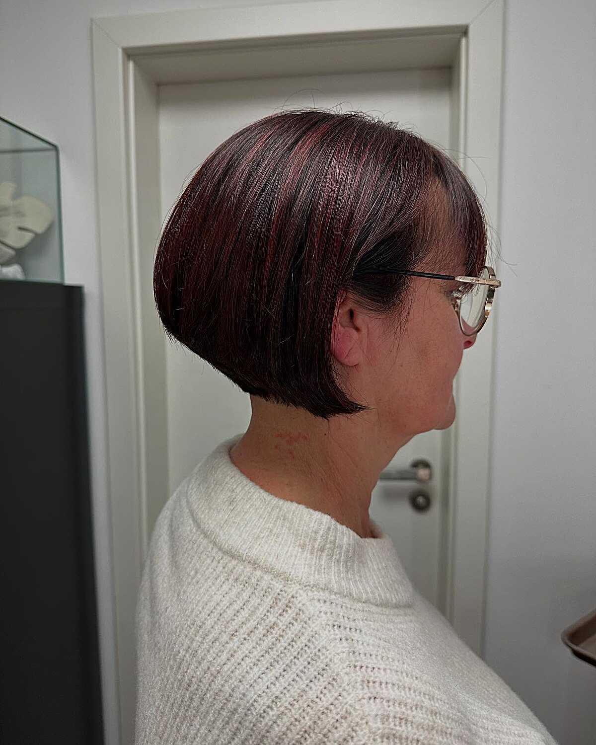 Short stacked bob in dark brown with plum red highlights