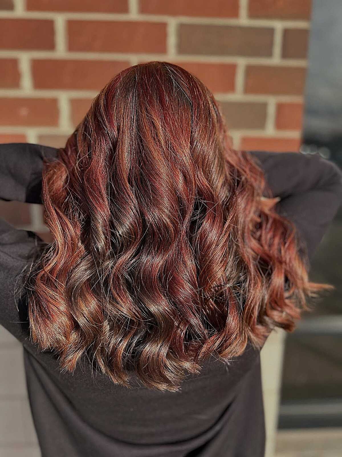 Wavy chestnut brown hair with rich auburn red highlights