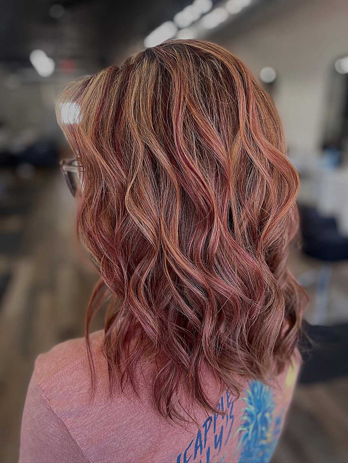 Wavy medium brown hair with rose gold red balayage