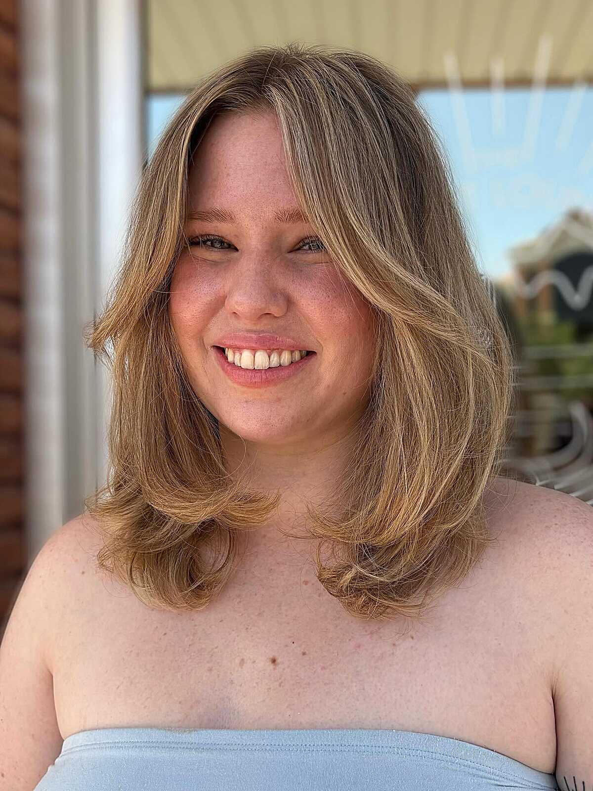 Sandy blonde medium layers with soft face framing pieces