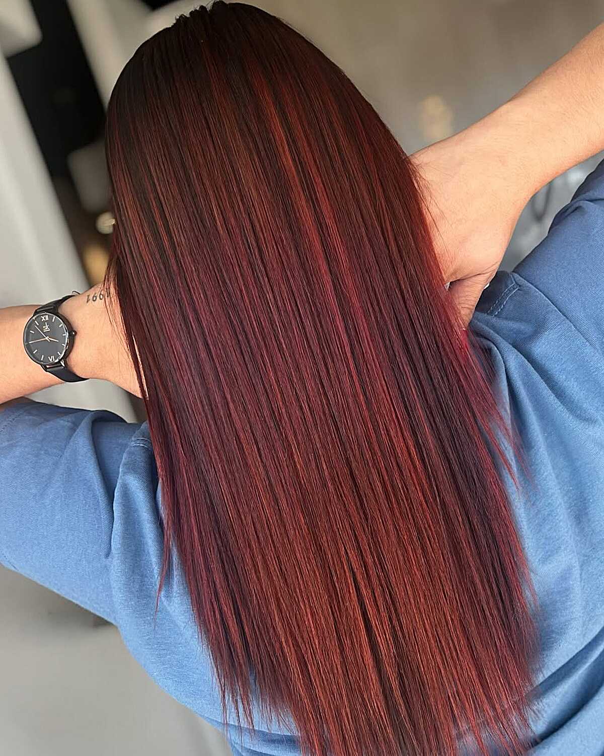 Long sleek near-black hair with cherry cola red highlights