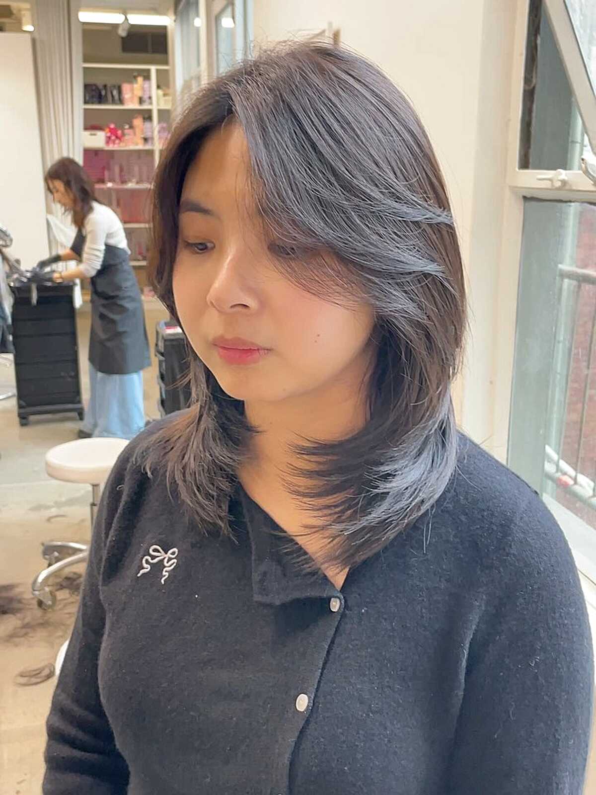 Cool brown medium layered hair with side-swept styling