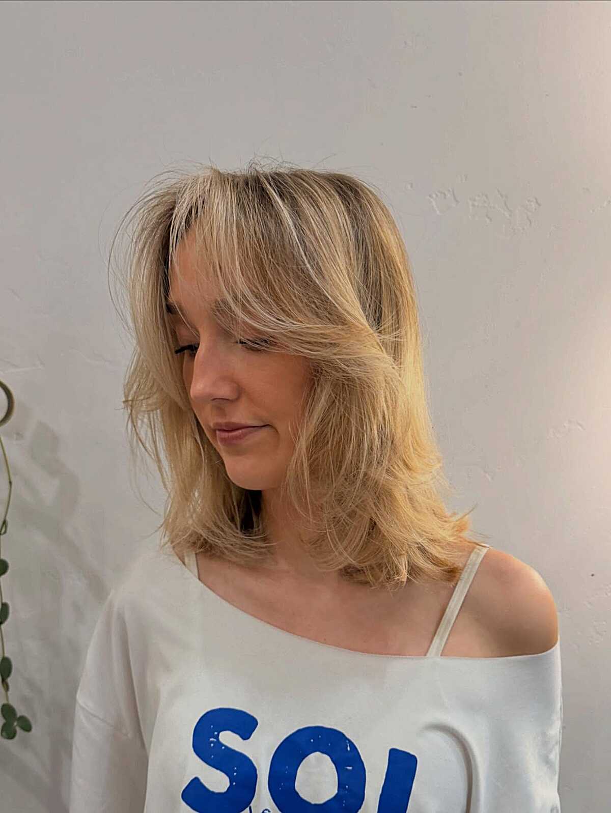 Sun-bleached blonde medium layers with feathered texture