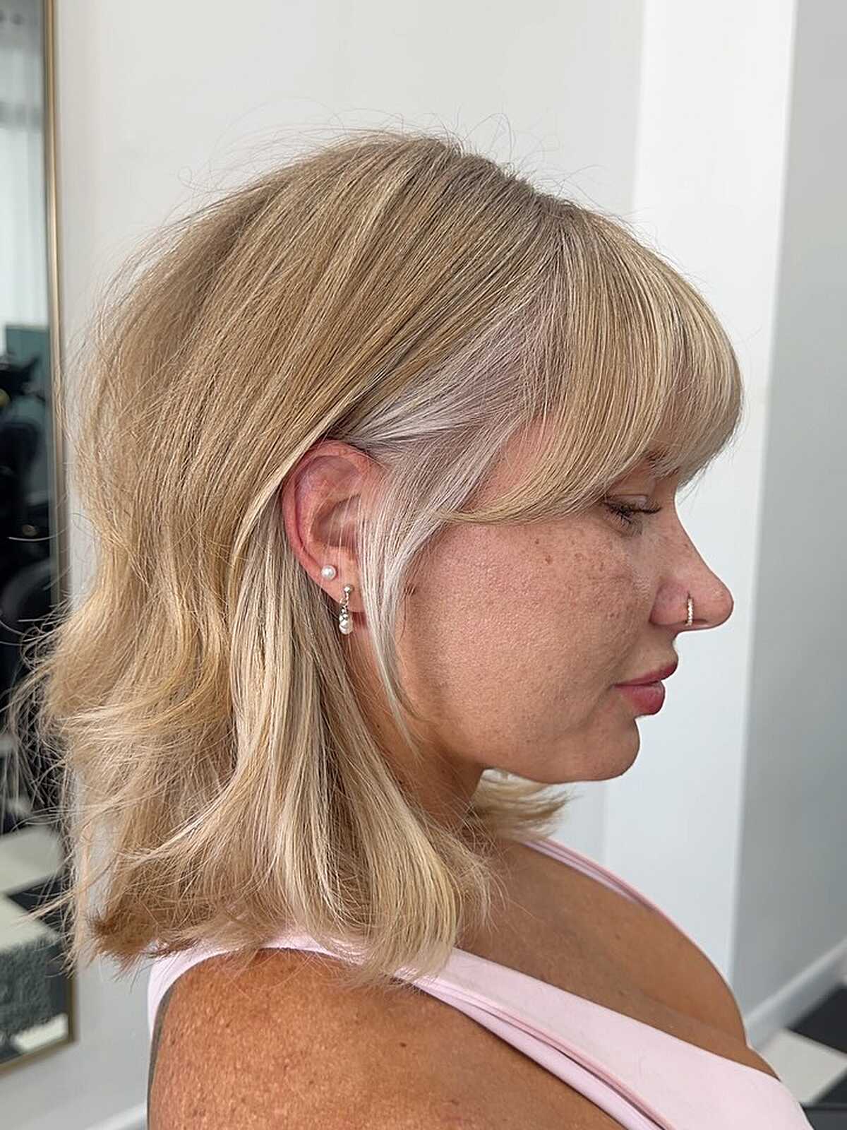Warm blonde chin-length layered bob with soft bangs