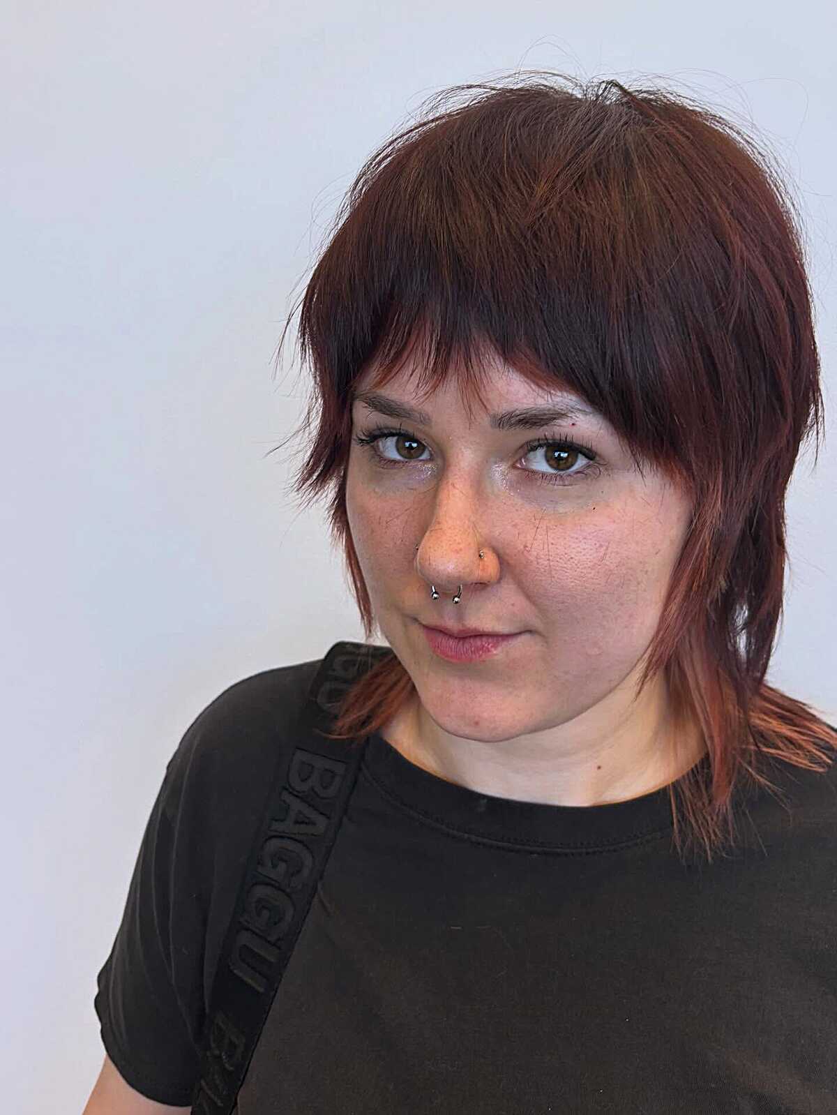 Auburn choppy mullet shag with wispy bangs and dark roots