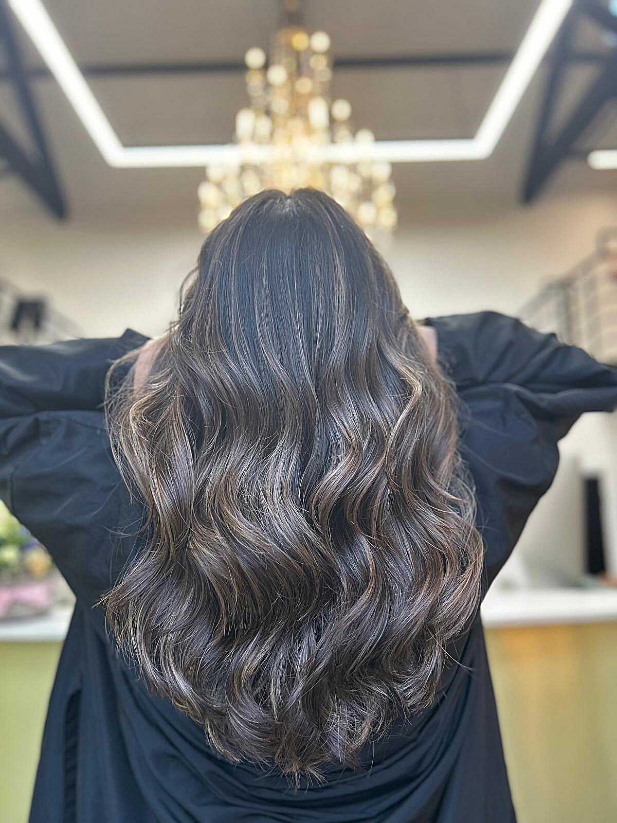 Very dark wavy hair with ash babylights in salon light