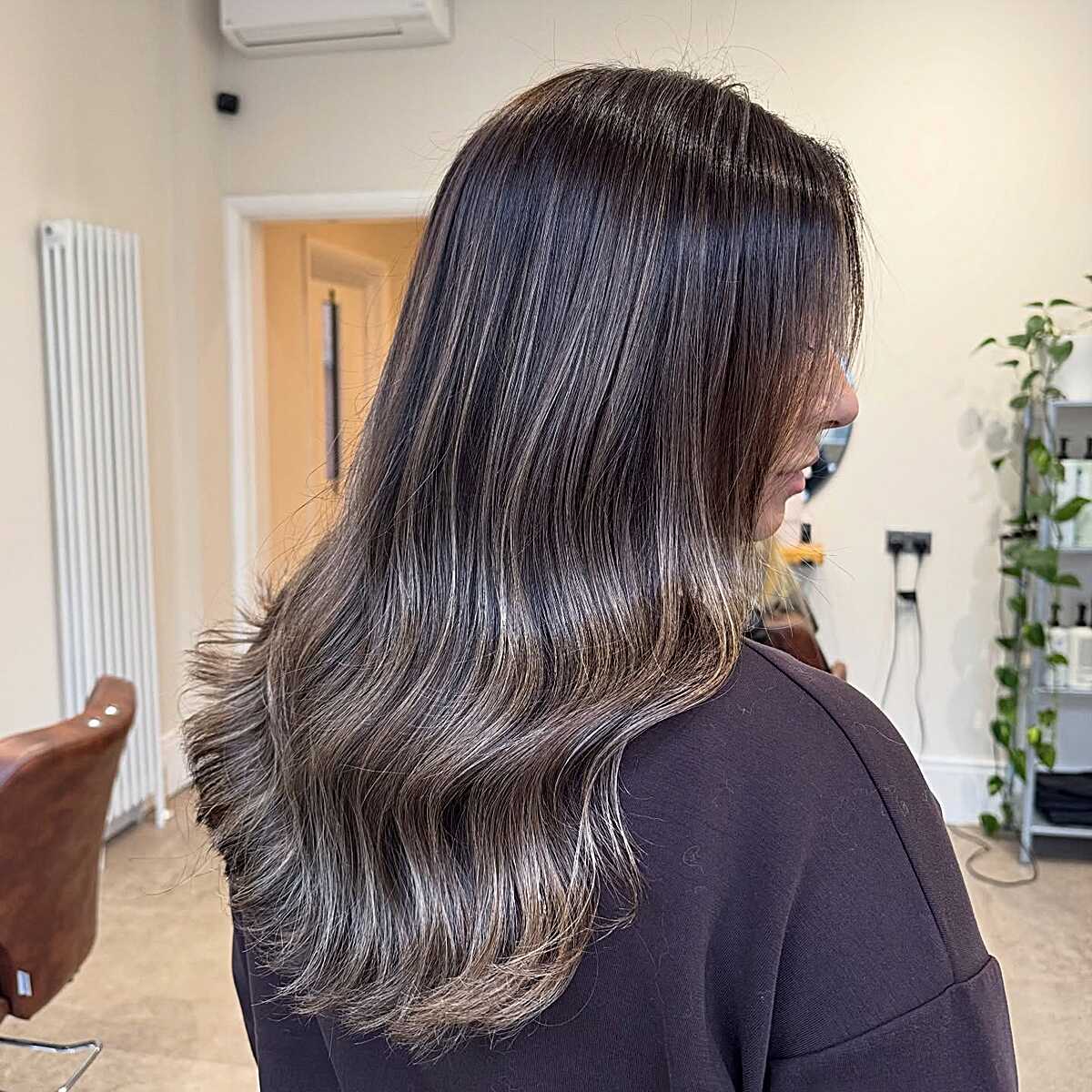 Dark shoulder-length hair with ashy babylights at ends