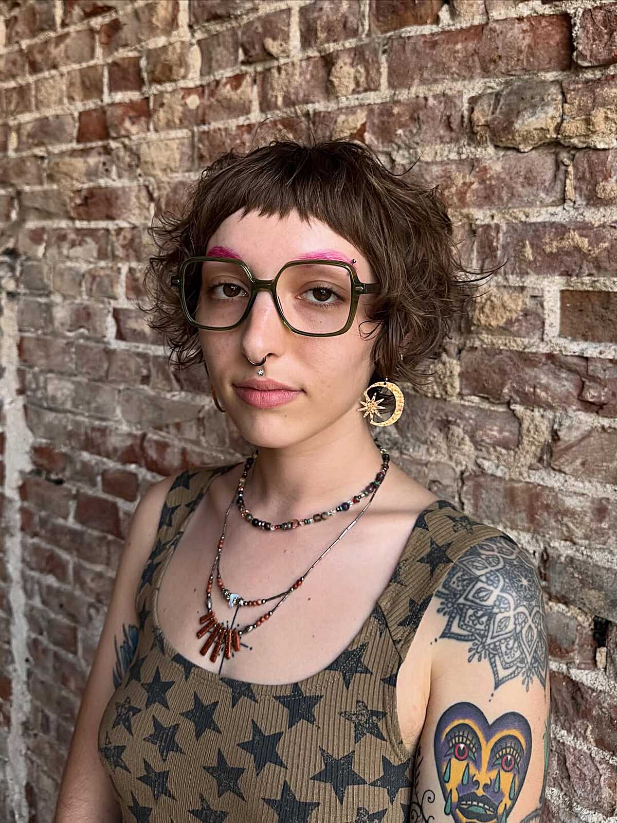 Curly brown short crop with baby bangs and pink brows
