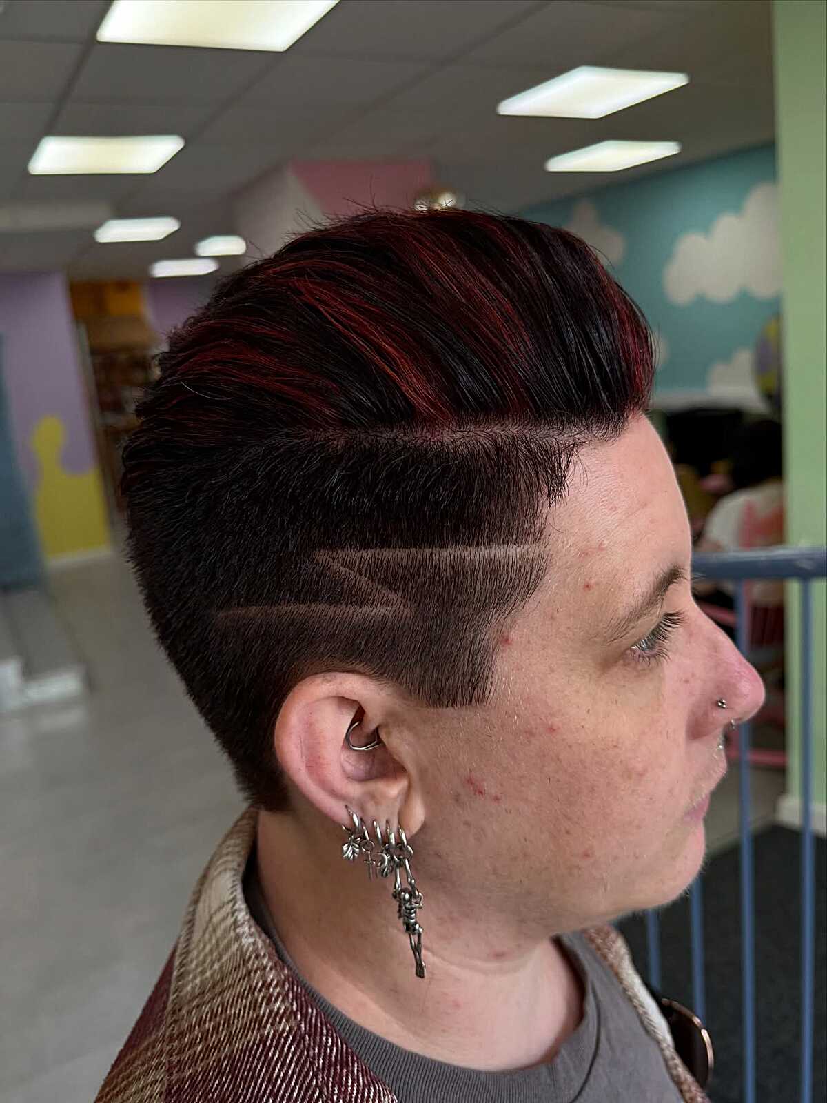 Dark red pompadour with shaved line design on sides