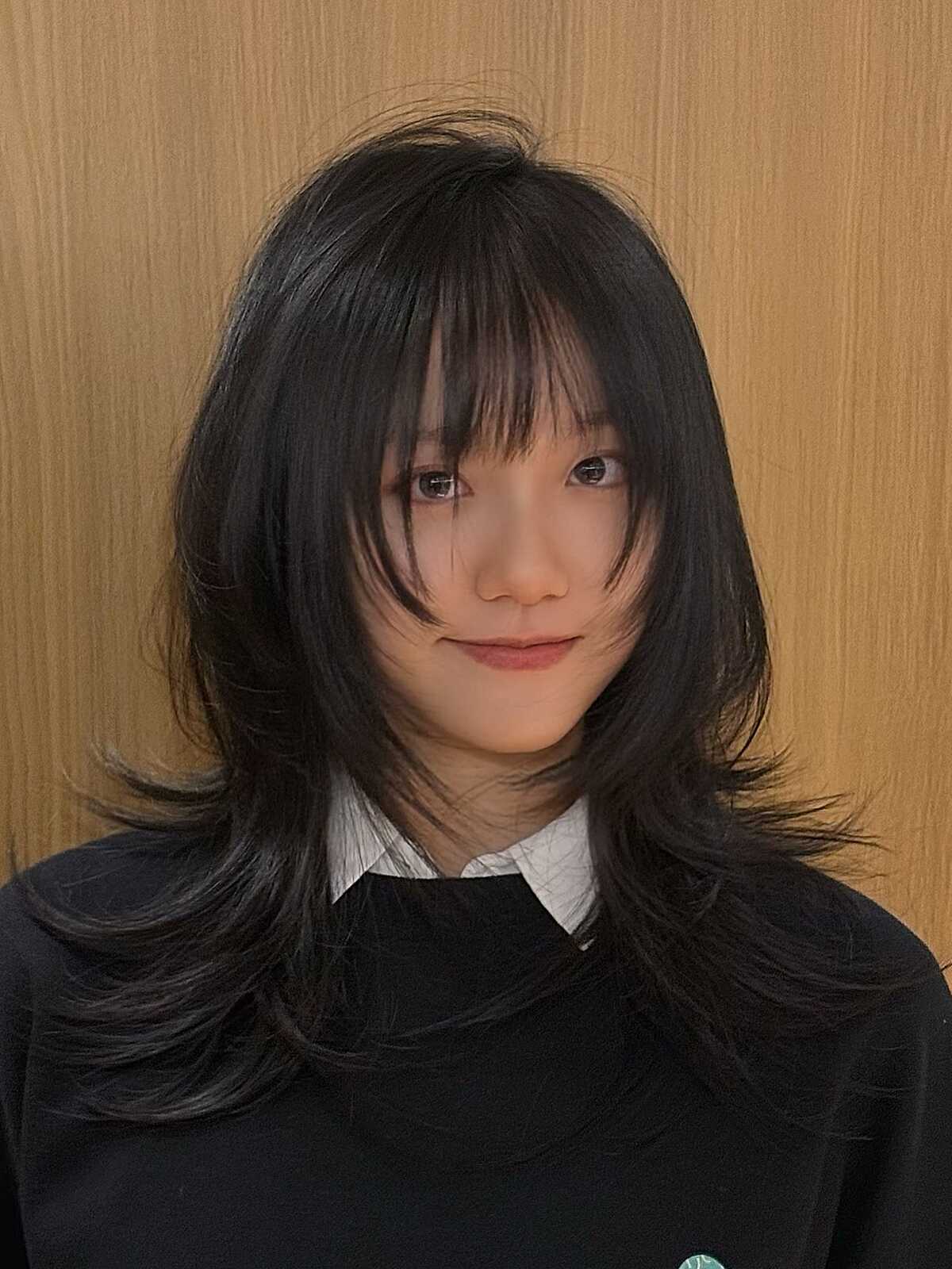 Medium-length jet black hush cut with shaggy full bangs