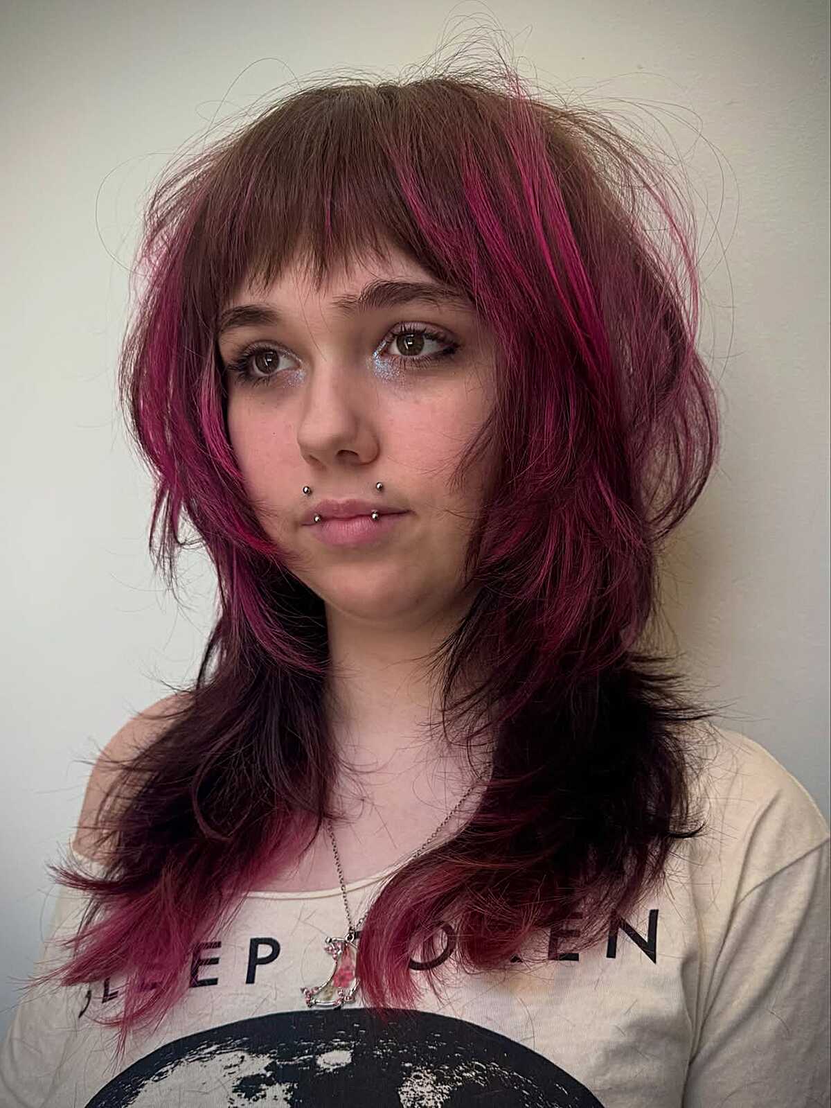 Long layered shag with magenta pink streaks on brown hair